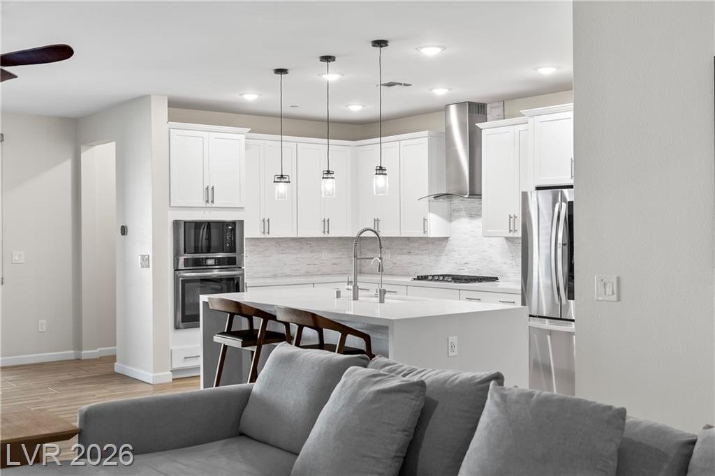 Great room sectional facing the white kitchen and pendant lights