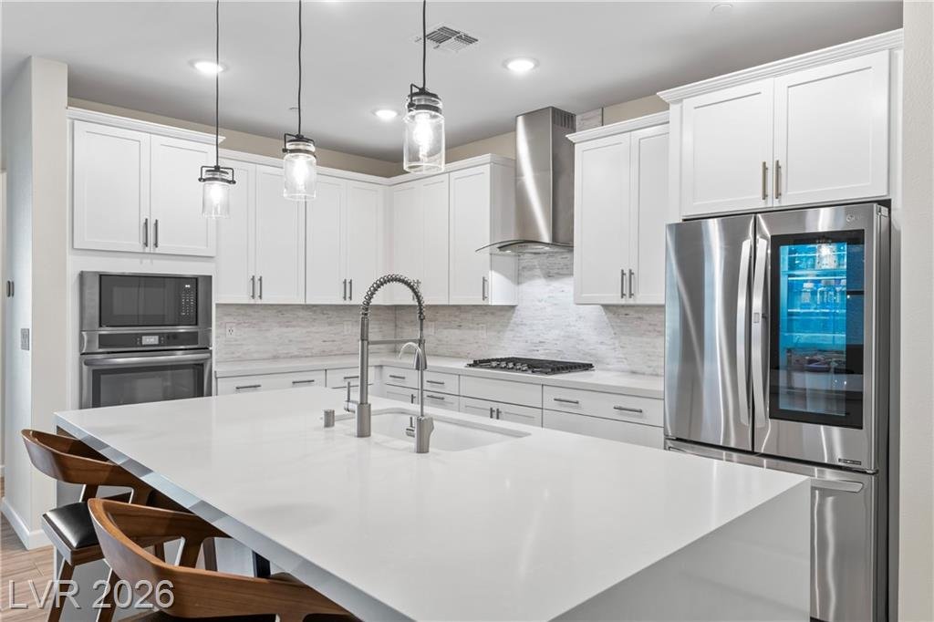 Quartz island with seating and a stainless French-door refrigerator