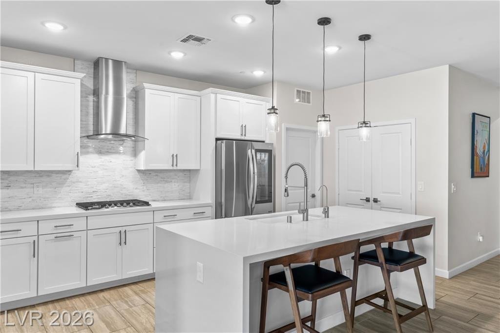 Gas cooktop, chimney hood and stacked stone backsplash