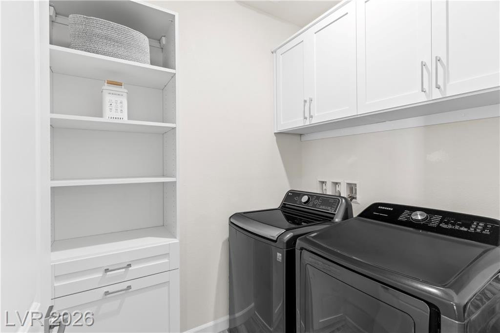 Laundry room with custom California Closets shelving and front-load washer and dryer