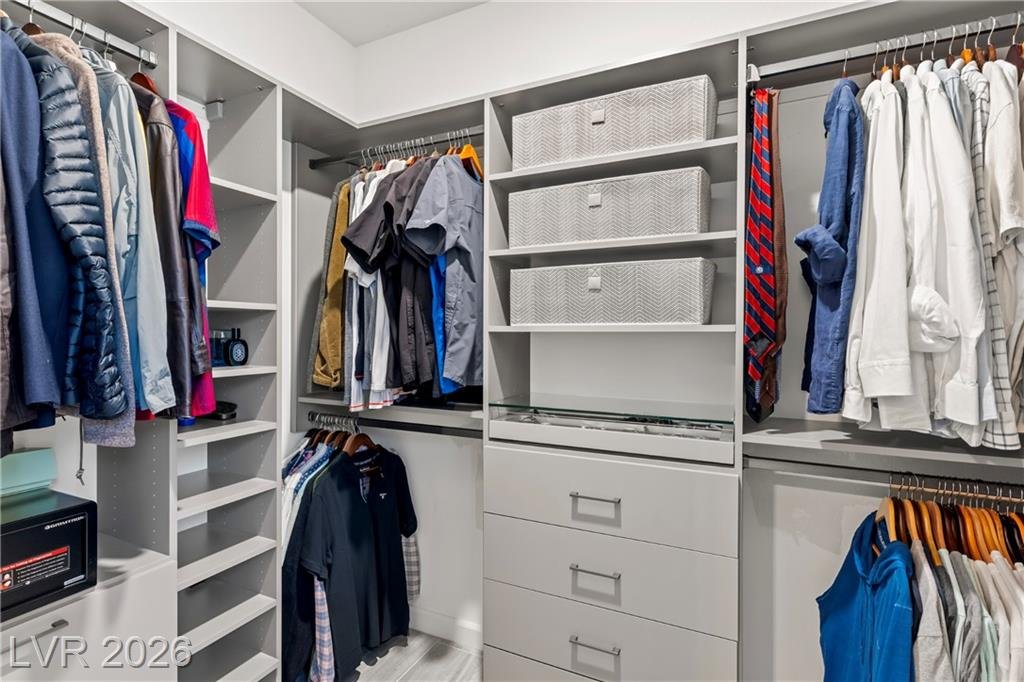 Primary walk-in closet with custom California Closets system