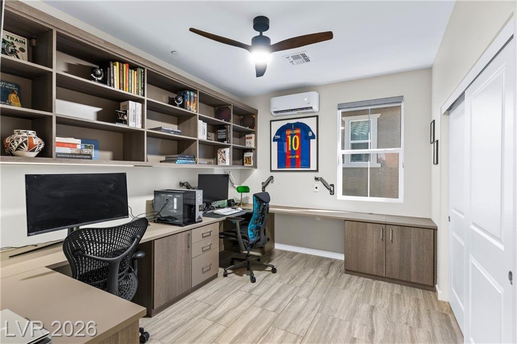Home office with a custom built-in desk, shelving and mini-split