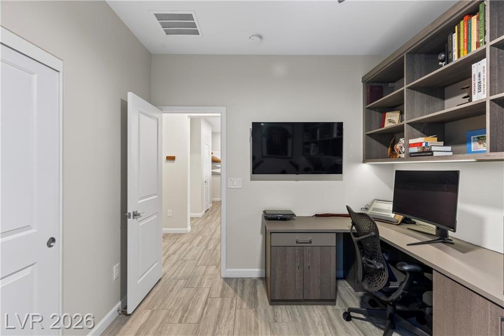 Office built-ins and wall-mounted TV toward the hallway