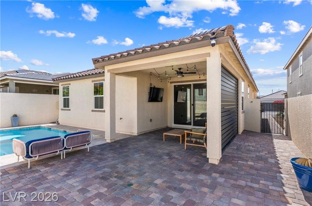 Back of the home with the covered patio, pool and paver deck