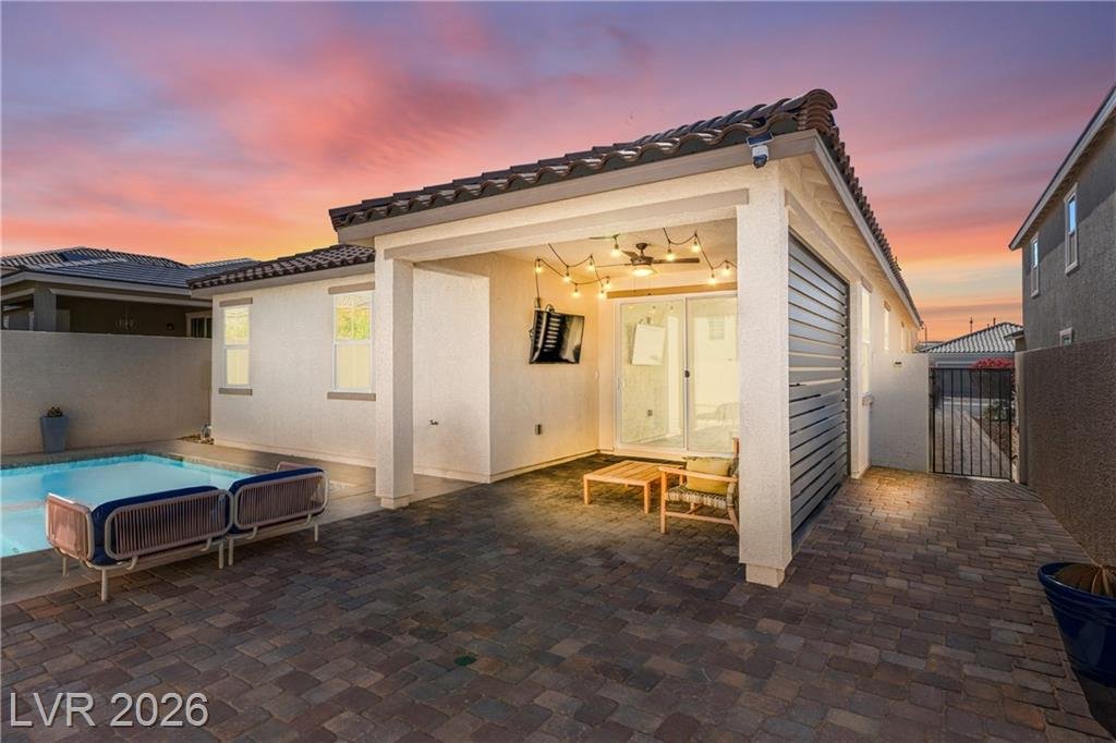 Twilight backyard at 3500 Brezine Avenue with lit patio and pool