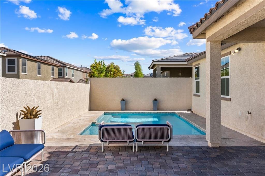 Heated pool and spa at 3500 Brezine Avenue with lounge seating and block-wall privacy