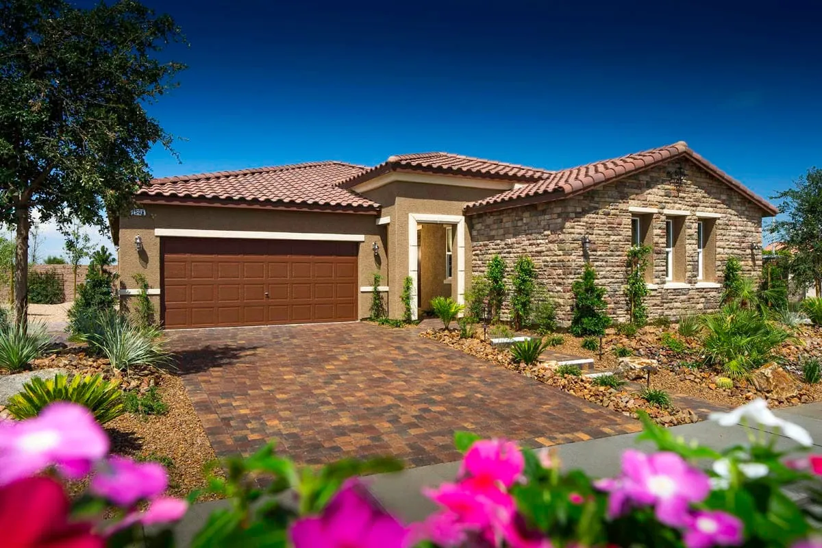 Single-story model home with a paver driveway and stone accents at Terraces by KB Home in Inspirada, Henderson NV